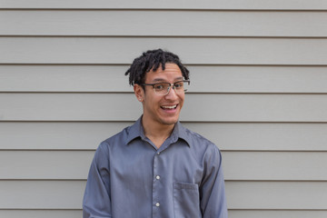 Happy biracial millennial man with open smile laughing, natural dreadlocks, new professional, horizontal aspect