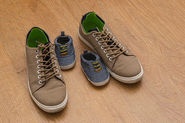 stylish men's and children's sneakers on the floor. Shoes after a walk top view