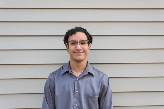 Smiling handsome young biracial man, millennial with dreadlocks, horizontal aspect