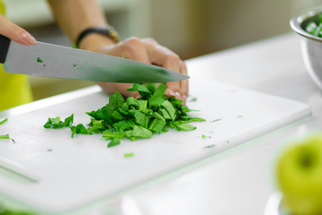 Cook in the kitchen cuts greens a