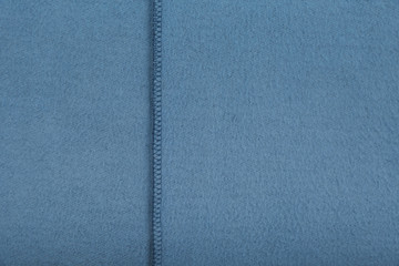 background of blue fleece fabric with a seam