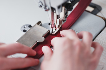 A leather craftsman produces leather goods on a sewing machine in his shop.