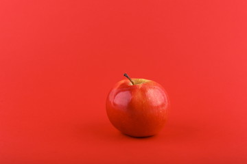 red apple on red background with copy space