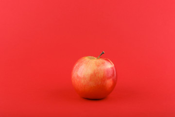 red apple on red background with copy space
