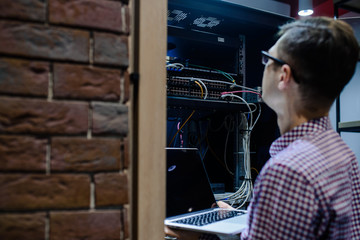 In the server room a technician/ It engineer/ hold the notebook