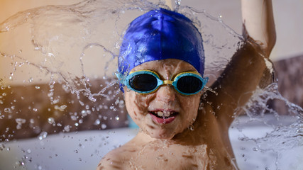 Close up happy little kid boy in swimming cap and glasses