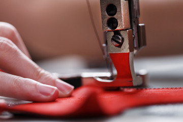 A leather craftsman produces leather goods on a sewing machine in his shop.