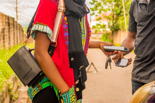 Young African Woman Paying A Mechanic Who Helped Fixed Her Car Via Mobile Transfer