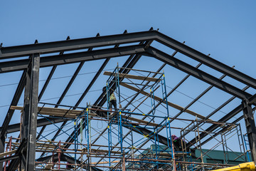 Worker installing structure of roof steel for new house