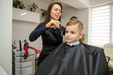 Close up picture of boy/child kid, sitting in the hairdressing salon