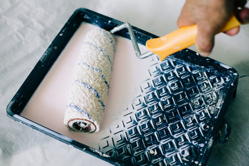 the roller is wetted in a liquid primer in a plastic black container, before painting the walls...