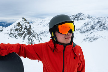 Fototapeta na wymiar Whistler, British Columbia, Canada. Adventurous Man with a snowboard in the Alpines on top of Blackcomb Mountain. Portrait