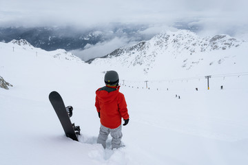Whistler, British Columbia, Canada. Adventurous Man with a snowboard in the Alpines on top of Blackcomb Mountain.