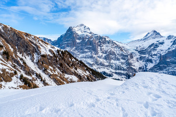 Fototapeta na wymiar Winter landscape with snow covered peaks seen from the First mountain in Swiss Alps in Grindelwald ski resort, Switzerland