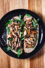 Top view of two vegan sandwiches with fresh arugula, fried shiitake mushroom and shallot onion.