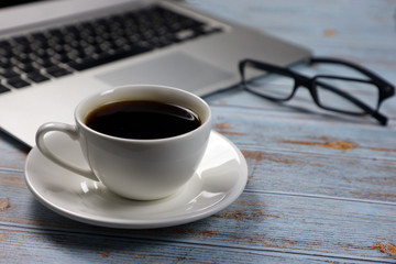 cup of coffee, keyboard and glasses on the table in the office, business and finance concept