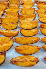 Baked potato wedges on parchment paper.