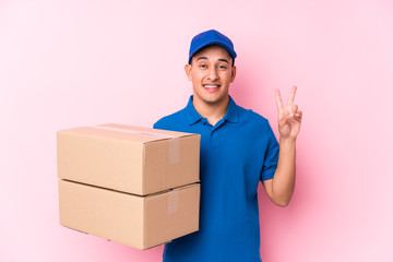 Young latin delivery man isolated joyful and carefree showing a peace symbol with fingers.