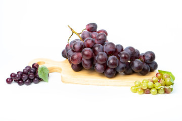 Purple grapes on a chopping block White background