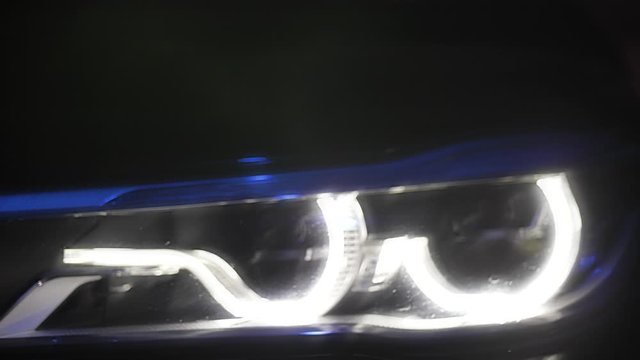 Adaptive LED optics luxury car, close shot, color light and smoke
