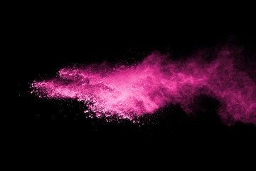 Pink powder explosion on black background. Colored cloud. Colorful dust explode. Paint Holi.
