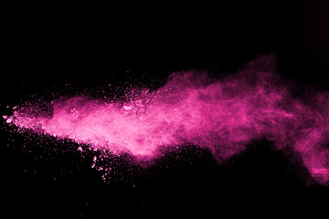 Pink powder explosion on black background. Colored cloud. Colorful dust explode. Paint Holi.