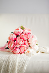 Bouquet of arfificial peony flowers on a white tablecloth