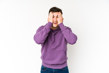 Fototapeta premium Young man isolated on white background having fun covering half of face with palm.