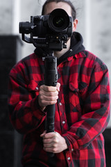 Young Professional videographer holding professional camera on 3-axis gimbal stabilizer. Pro...