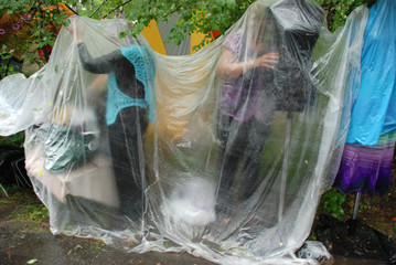 People in the rain under a plastic film.