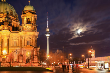 Street view of St. Mary Church and TV Tower at night in Berlin, Germany.