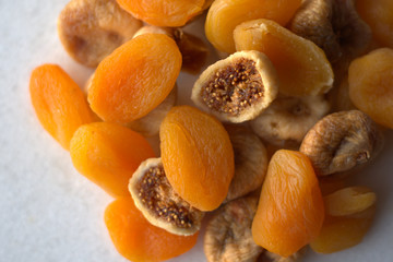 Dried figs and apricots on white background 