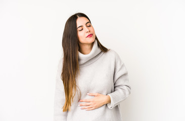 Young caucasian woman isolated on a white background touches tummy, smiles gently, eating and...