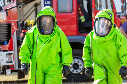 Two firefighters in protective suit for hazardous material during a public demonstration