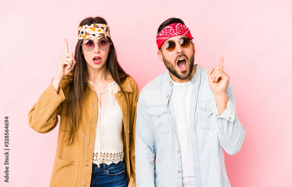 Wall mural Young caucasian couple wearing a music festival clothes isolated having an idea, inspiration concept.