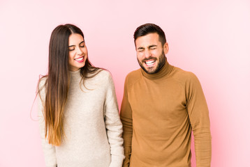 Young caucasian couple isolated laughs and closes eyes, feels relaxed and happy.