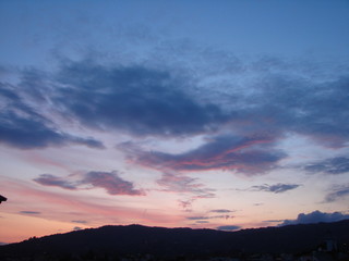 Unique landscape and variety of sunset colors over the Italian town against the background of mountains on the horizon.