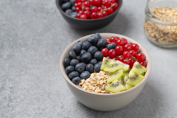 Healthy delicious Breakfast. Muesli with blueberries, red currants, kiwi and yogurt.