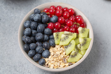 Healthy delicious Breakfast. Muesli with blueberries, red currants, kiwi and yogurt.