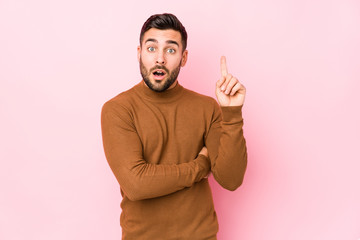 Young caucasian man against a pink background isolated having some great idea, concept of creativity.