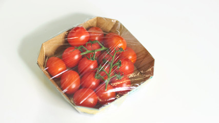 Woman using food film for food storage on a white table. Roll of transparent polyethylene food film for packing products.