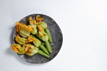 Fresh uncooked green and yellow zucchini flowers. Vegan nutritious food. Clean eating concept. Bacground, copy space, close up, top view.