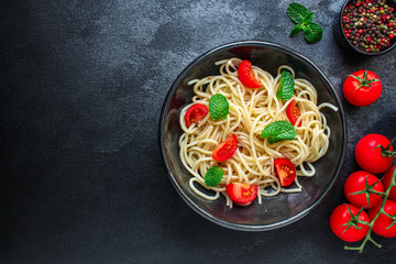 spaghetti pasta with tomatoes, Italian cuisine main dish, vegetarian menu concept background. top view. copy space