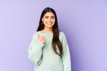 Fototapeta premium Young indian woman isolated on purple background smiling and raising thumb up