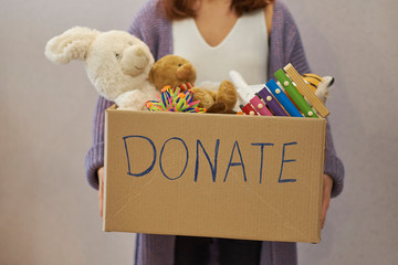 Donation box with children toys. woman collects toys for charity.