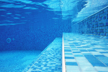 Fototapeta na wymiar Underwater shot of stairs and tiles on pool bottom