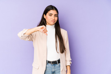 Young indian woman isolated on purple background showing a dislike gesture, thumbs down. Disagreement concept.