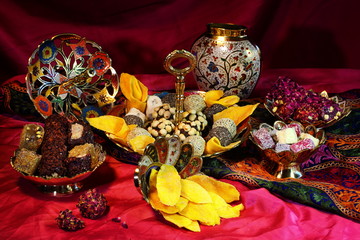 Oriental sweets on a red background in copper utensils