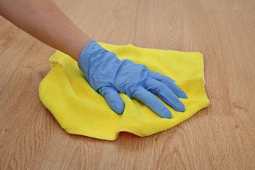Laminate floor cleaning, closeup of hand in glove with rag