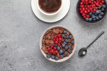 Chocolate corn flakes in a bowl with milk and berries. Delicious healthy Breakfast.